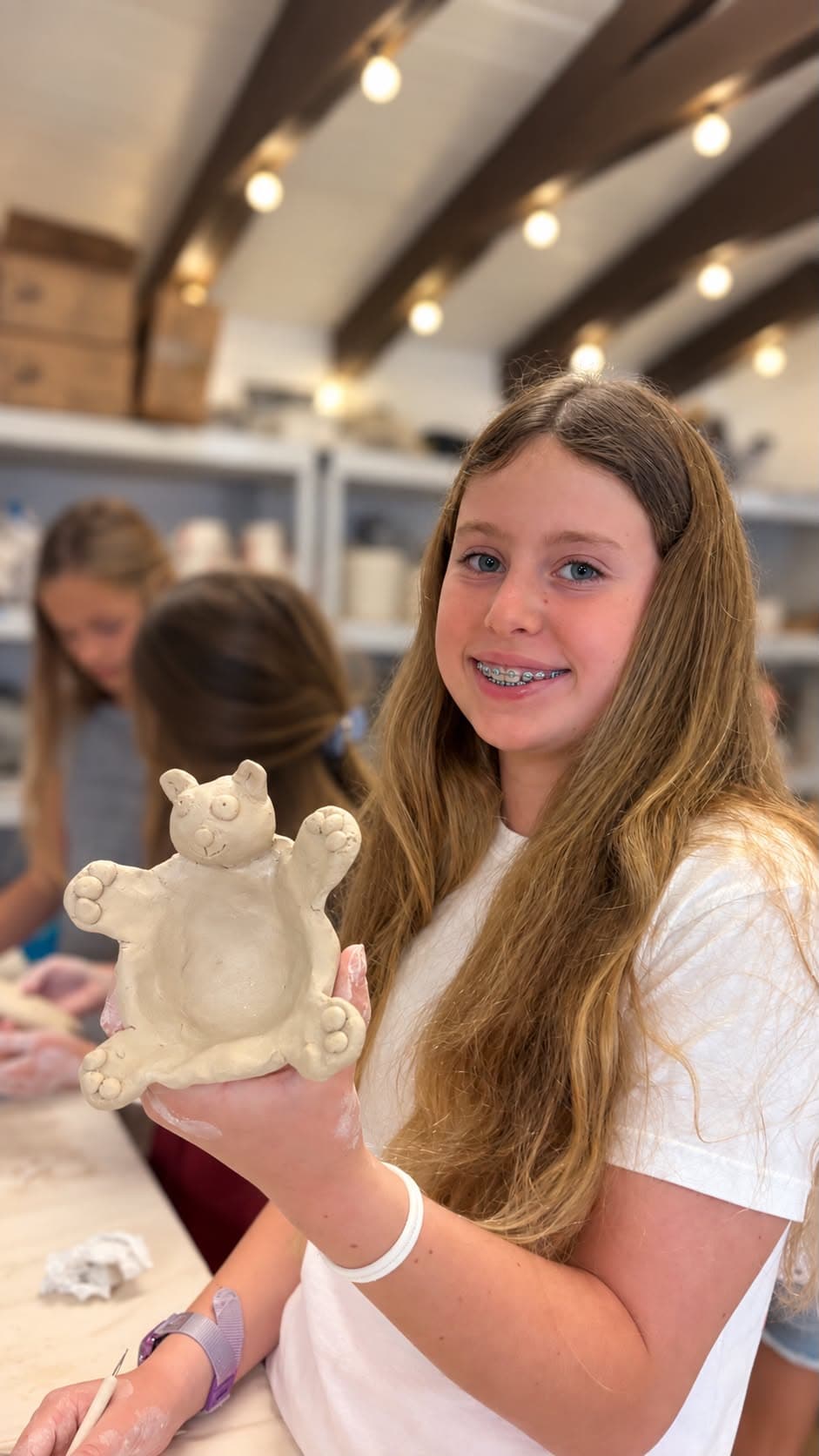 A proud artist with her clay teddy bear bowl
