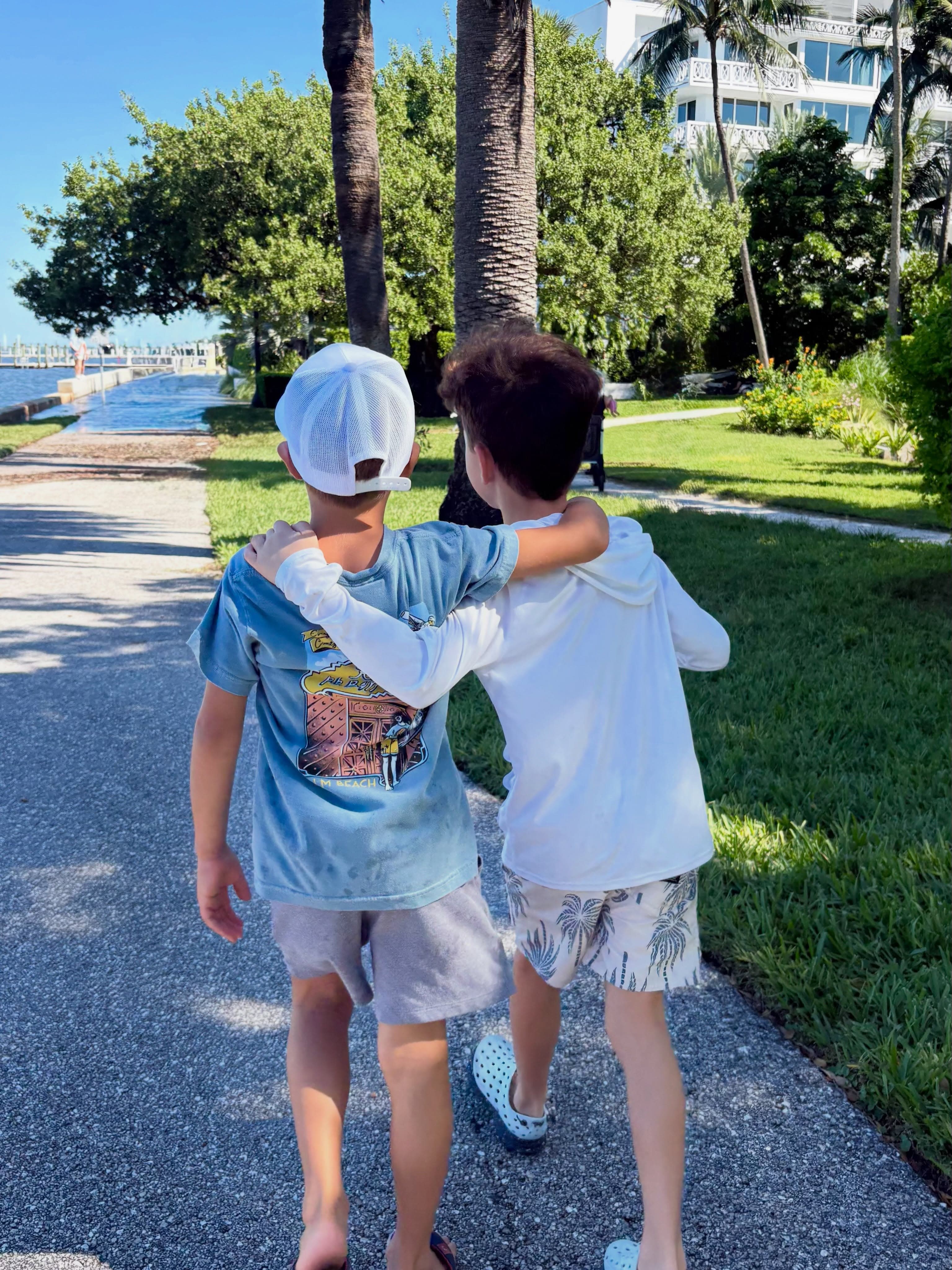 Two boys walking arm in arm to the fishing spot