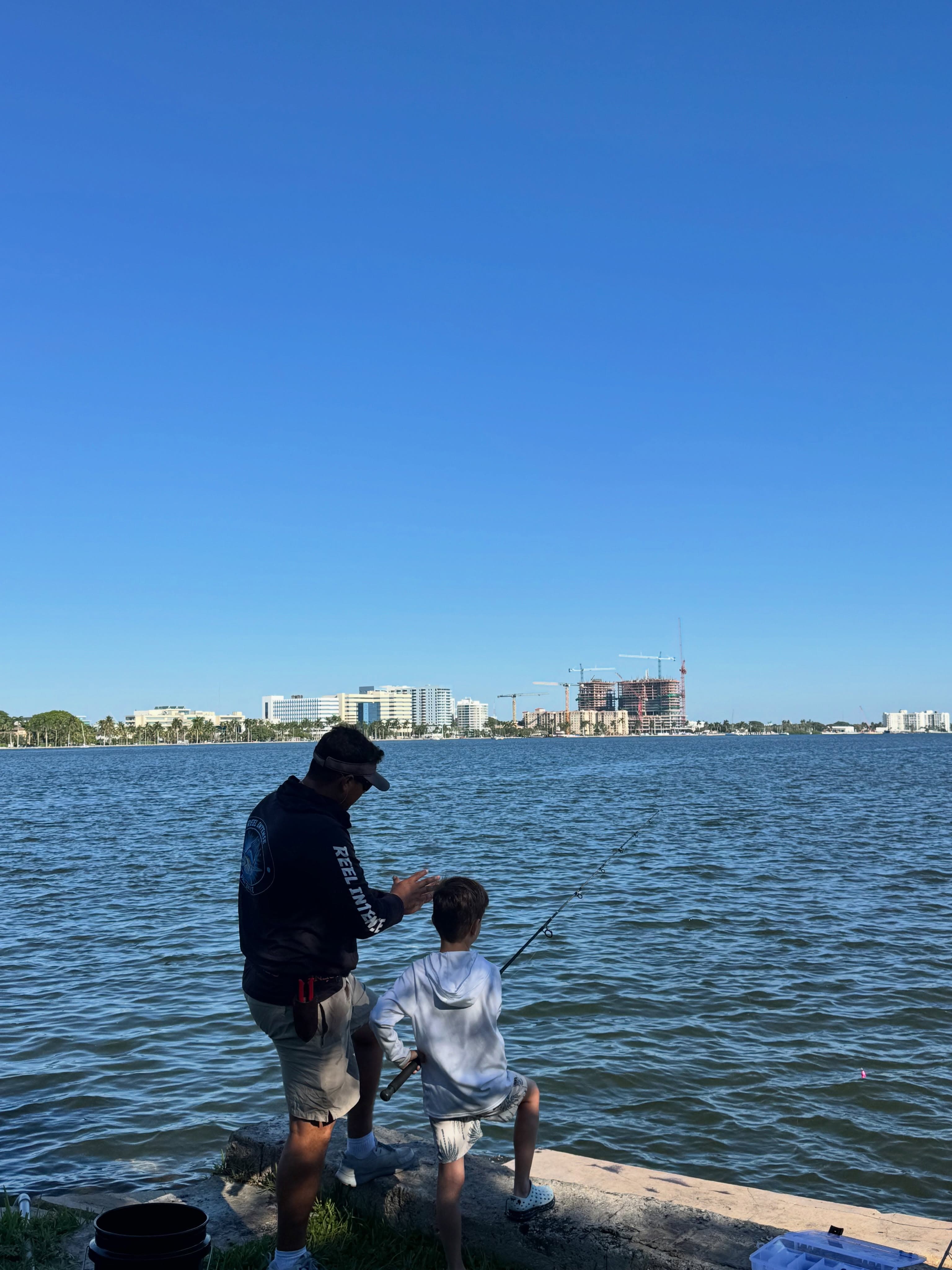 A young angler with his rod at the seawall