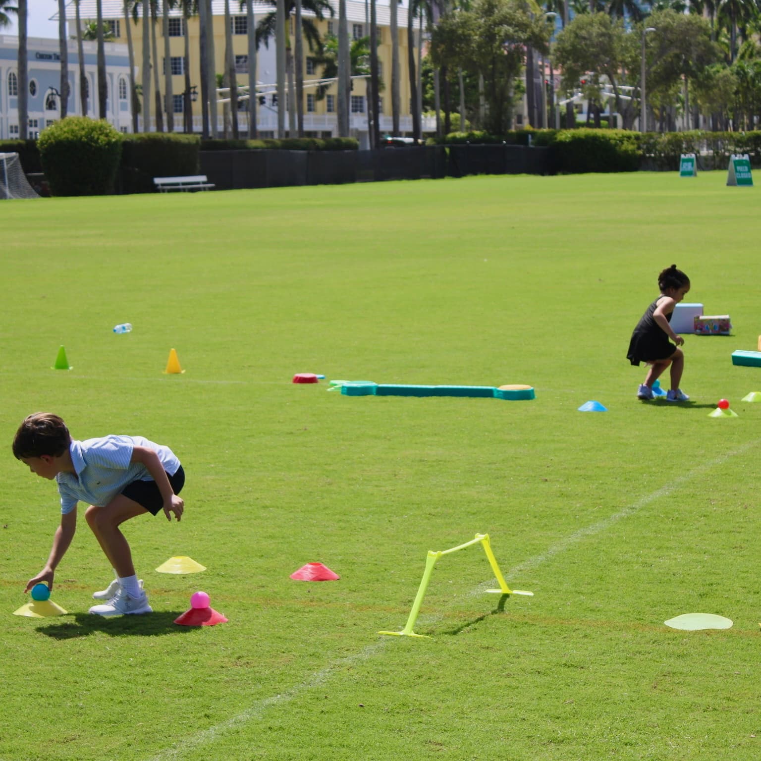 Kids picking up balls during a relay on the field